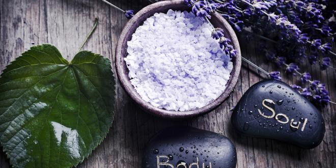 A green leaf with healing stones, a bowl with lavender herb salt and dry French lavender.