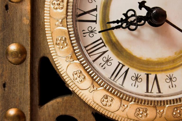 Old wooden clock showing time, close-up.