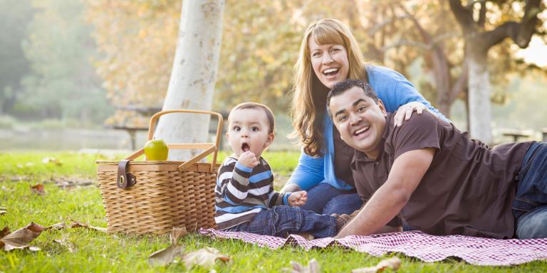 a young family enjoying lunch in the park